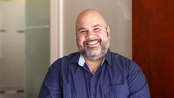 headshot of a man in a blue shirt