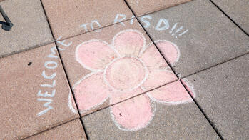 welcome to risd in chalk with a flower in the middle
