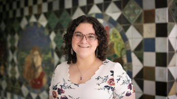 photo of a woman smiling in front of a tiled wall