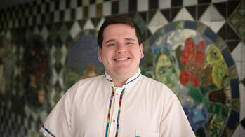 man smiling in front of tiled wall