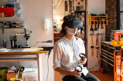 R I S D student using V R goggles in Co-Works lab