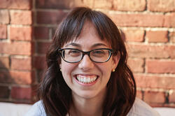 photo of a woman smiling with bangs and brown hair
