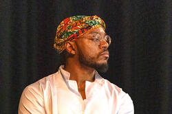 photo of a man looking to the left in a white polo shirt