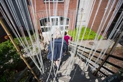 A student walks down a flight of steps through an art installation.