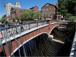 Two people walking across a bridge in Providence