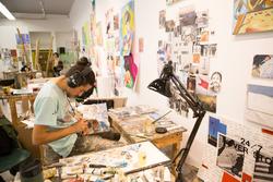 Person painting at a desk in a Memorial Hall studio.