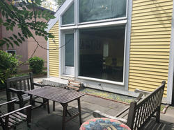 ISE patio, with outdoor chairs and a table infront of a large window
