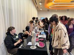 people looking at a table of student art for sale