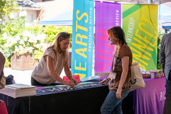 student talking to a staff member at a brightly colored risd careers table