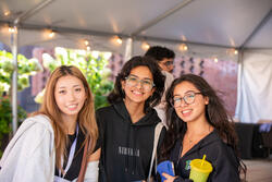 three students smiling at the camera