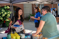 student talking to a staff member at a table with resources