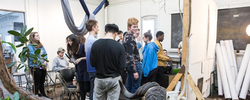 A group of students gathered in a busy drawing studio with specimens from the Nature Lab