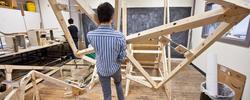 A RISD graduate student is constructing a large and elaborate wooden artwork.