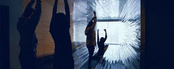 A group of graphic design students interact with an art installation.