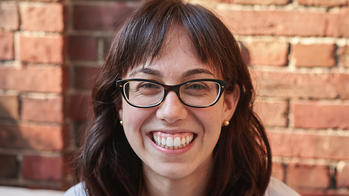 photo of a woman smiling with bangs and brown hair