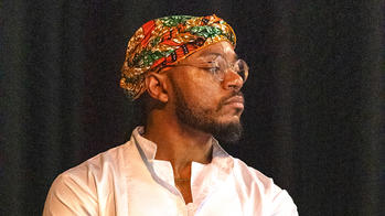 photo of a man looking to the left in a white polo shirt