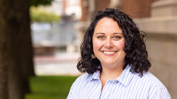 photo of a woman with brown curly hair smiling