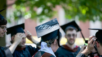 student with a grad cap that says hehe in googly eyes