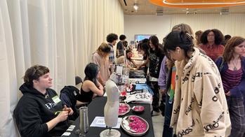 people looking at a table of student art for sale