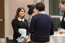 a student speaks to another portfolio review attendee as two other people talk in the background
