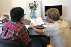 Two people are engaging in a peer tutoring session at a desk in the Center for Arts & Language.