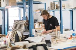 A RISD student is working on a project at an active workspace.