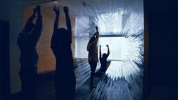 A group of graphic design students interact with an art installation.