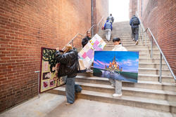 students on stairwell by risd museum holding large pieces of work