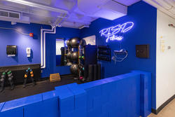 student fitness center free weight area with risd fitness neon sign