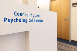 photo of the counseling and psychological services front desk, a white desk with the office name in blue on it
