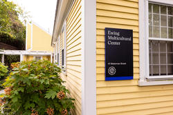 Photo of Ewing House, yellow house with blue and black sign on it