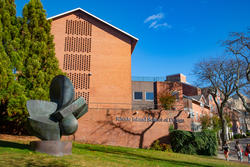 Image of a green space in front of a brick building that says Rhode island school of design on it in metal letters. 