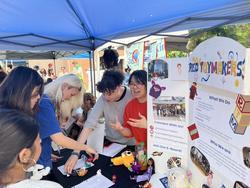 a group of students at a table with a sign that says risd toymakers